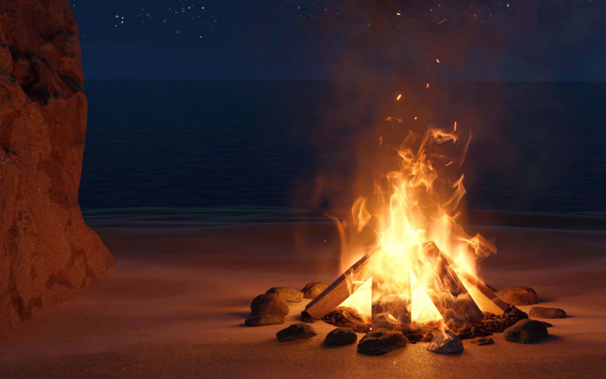 A fire burning on sand with a night sky behind it