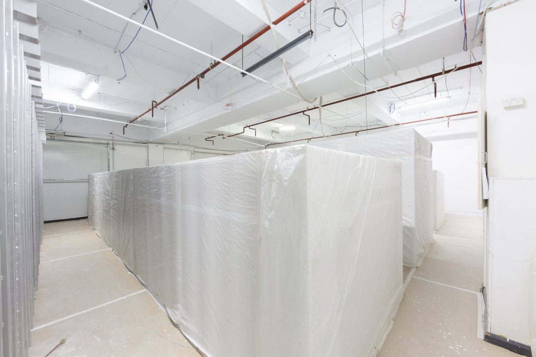 Library collection storage area with shelves covered in white fabric