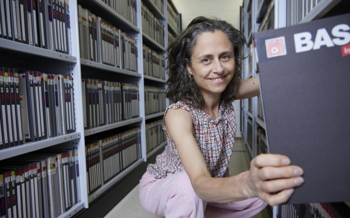 Alice Garner pulling out a book from the Library's hidden stacks