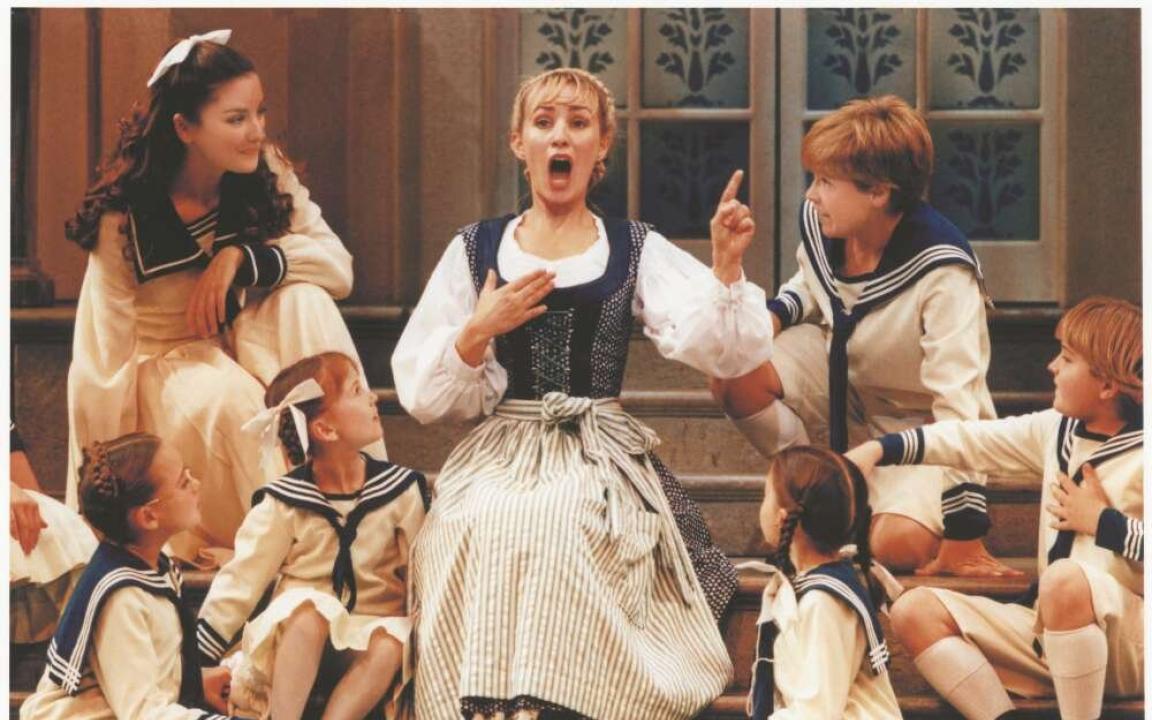 A woman sings as five other children watch her