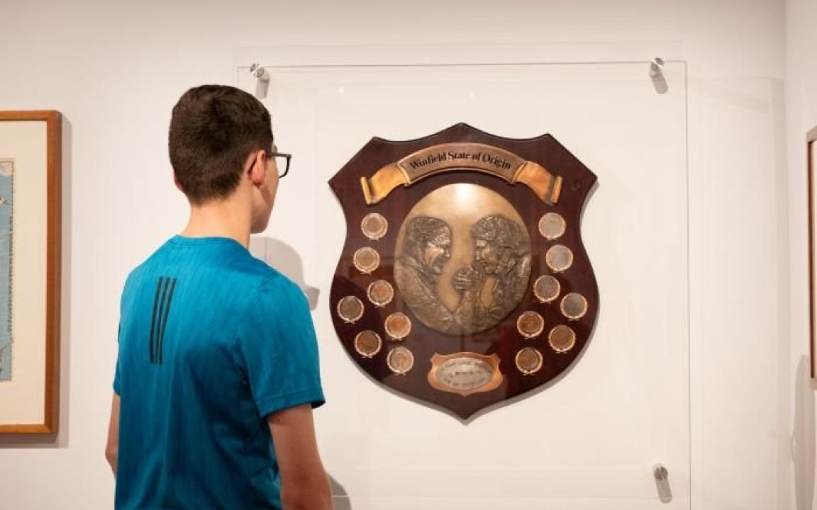 Boy looking at the Winfield State of Origin plaque