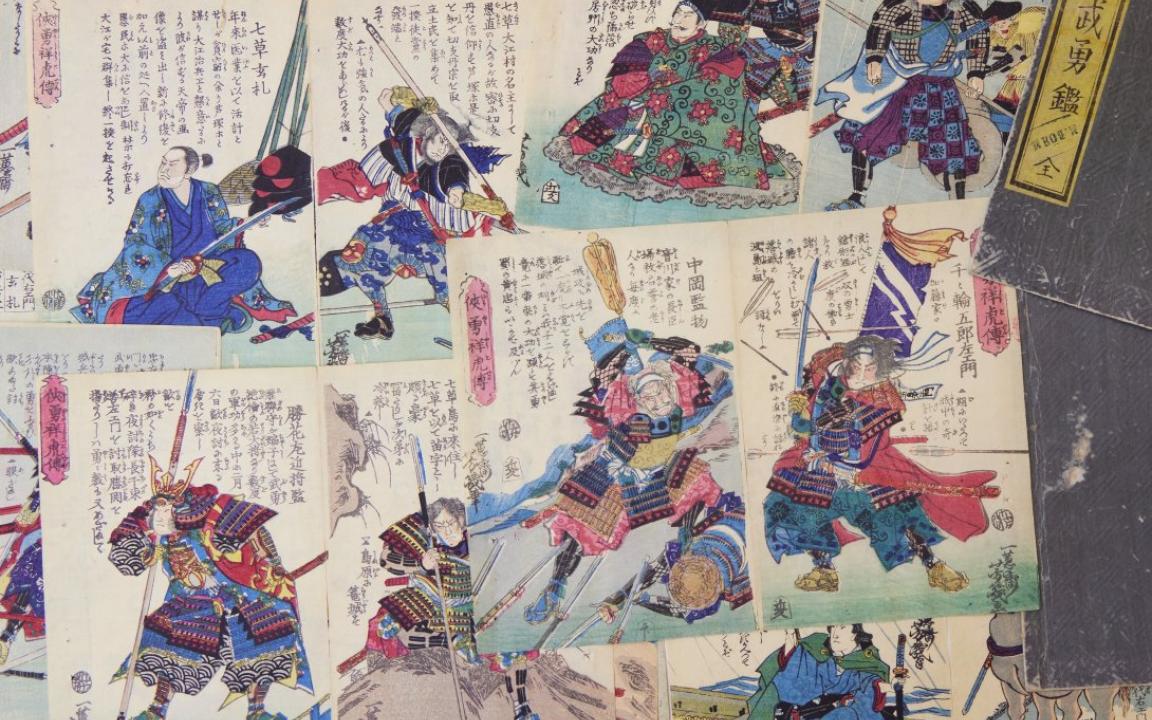 Pages with Japanese text and colourful, highly detailed, illustrations of samurai, men in armour and cultural dress with swords.  