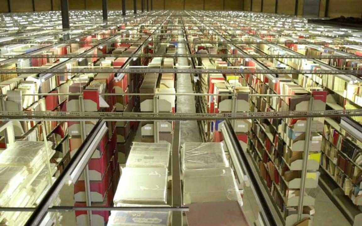 Rows of shelves containing books, papers, and other items