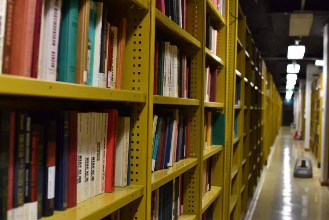 Metal shelves full of bound volumes in many different colours