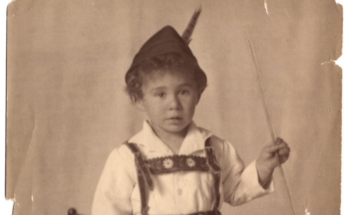 Sepia toned photo of young boy dressed in lederhosen