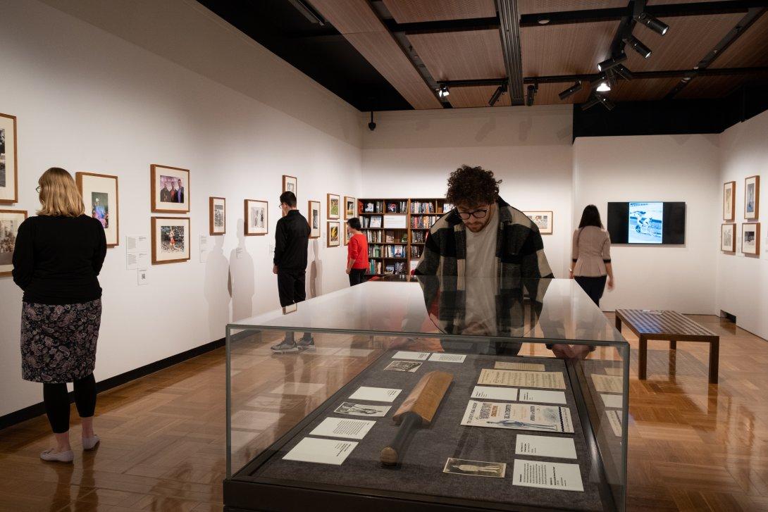 People in the gallery looking at Grit & Gold exhibition items