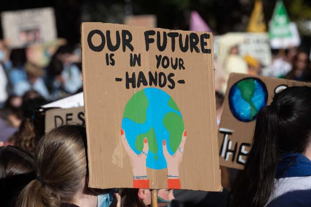 Protester holding a placard that reads, Our Future is in Your Hands