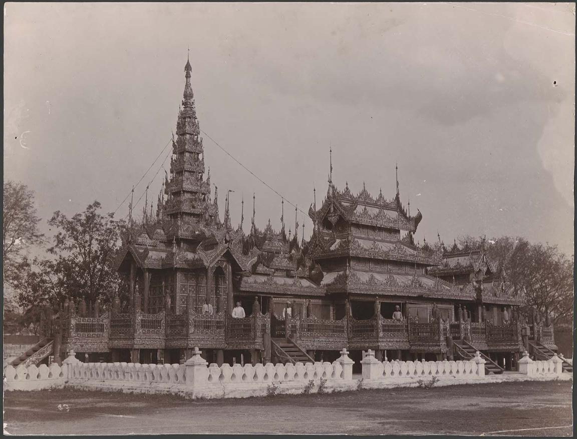 Sepia photograph of a monastery with people stanidng on the balconies