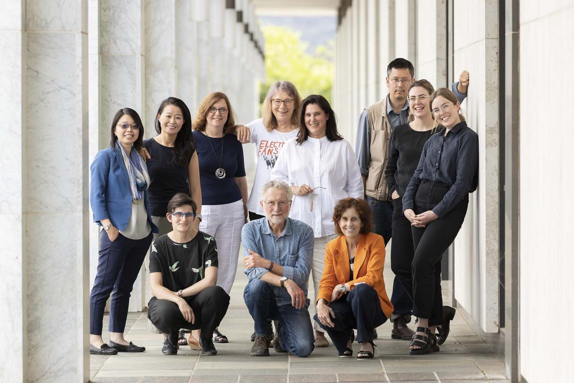 Eleven people posed for a photo under the National Library's exterior colonnade.