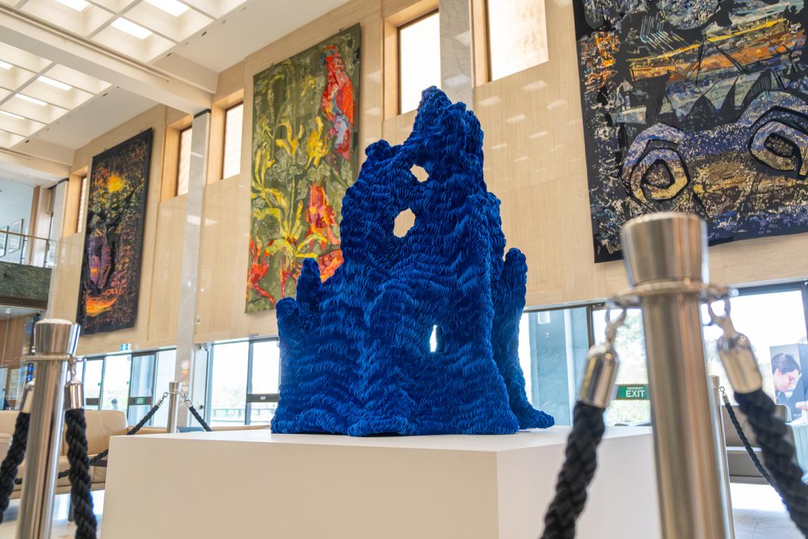 Blue velvet structural artwork on a white pedestal in the Library foyer