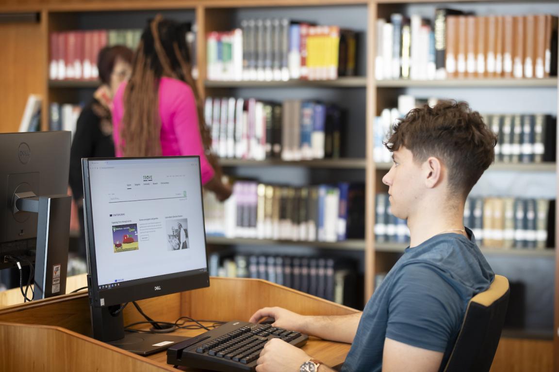 Young man browsing Trove on a computer in the Main Reading Room