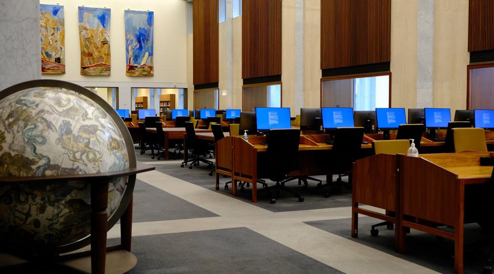 Rows of desks and computers in the Library's Main Reading Room. A large globe is in the foreground.