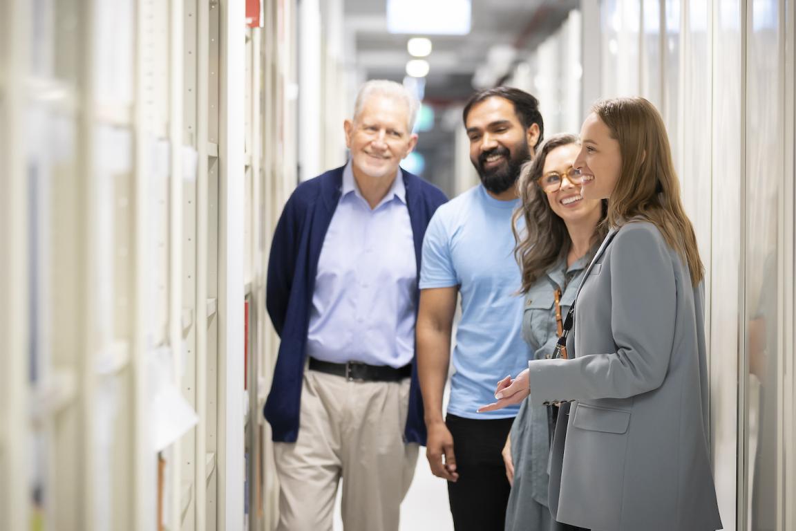 Tour guide taking three people through the Library's stacks